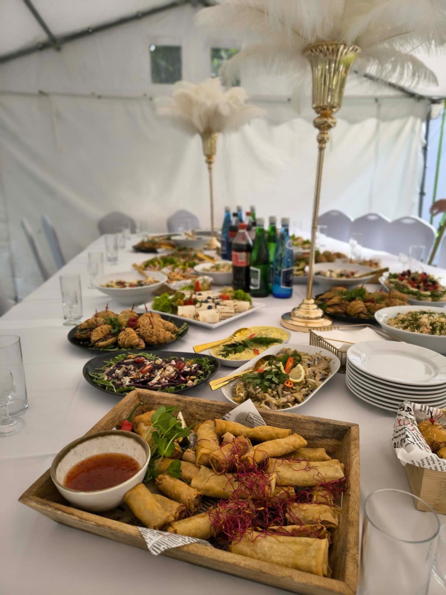 Sajgonki, sałatki i przekąski na eleganckim stole